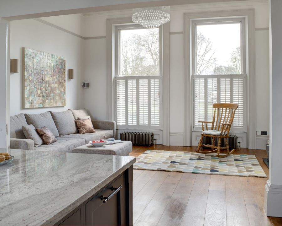 Large, floor-to-ceiling windows flood a bespoke living room with natural light. 