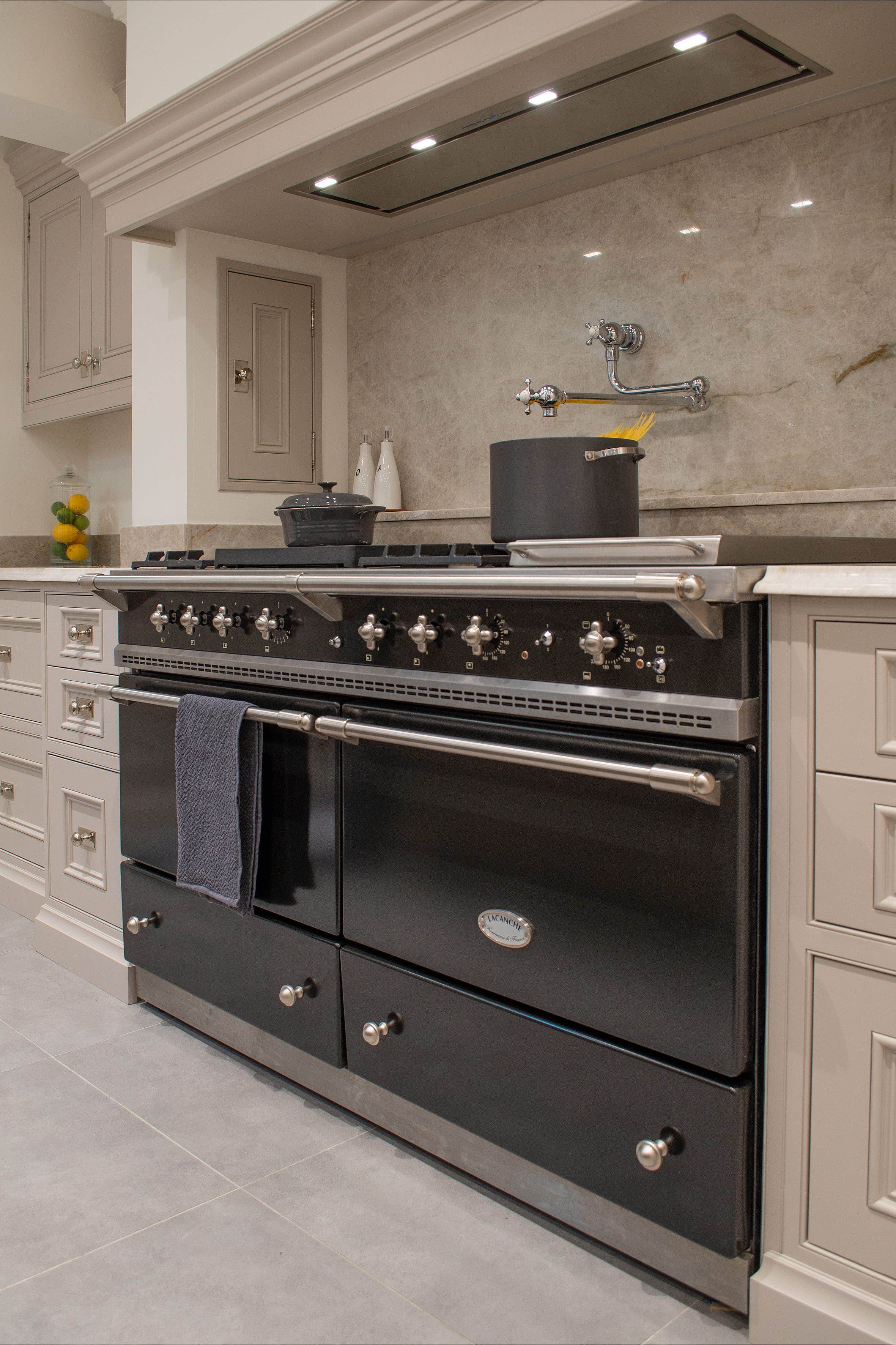 A large range cooker, with a large marble splashback.