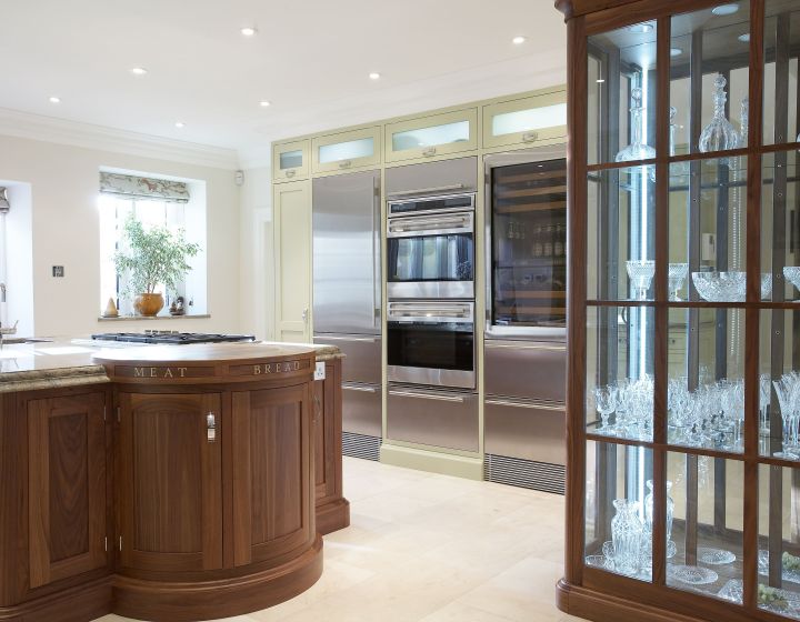 A bespoke shaker kitchen with a centre island with a wine rack, and bespoke glass shelf.