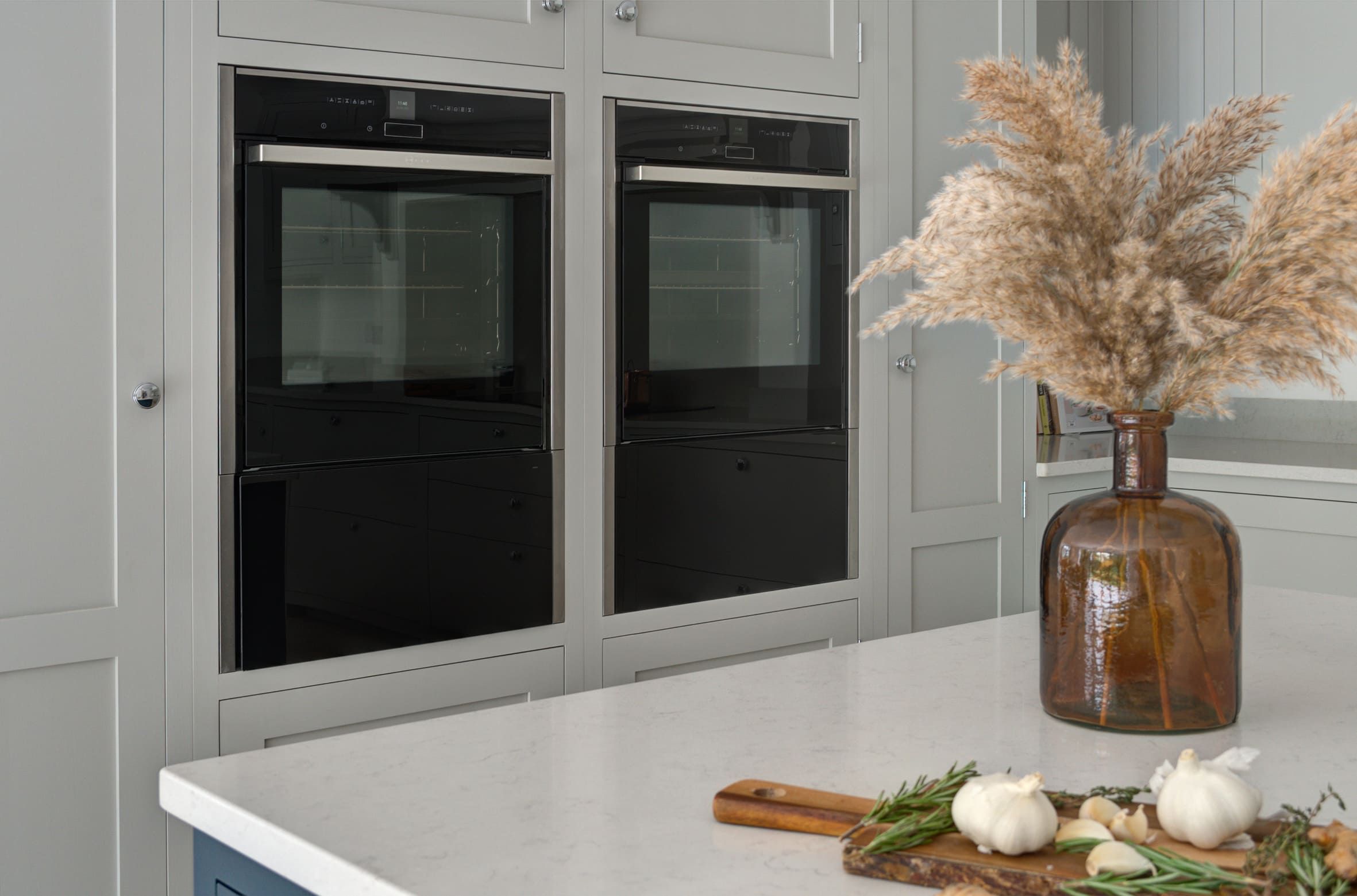 2 large, integrated ovens, surrounded by white cabinets, showing ample storage space.