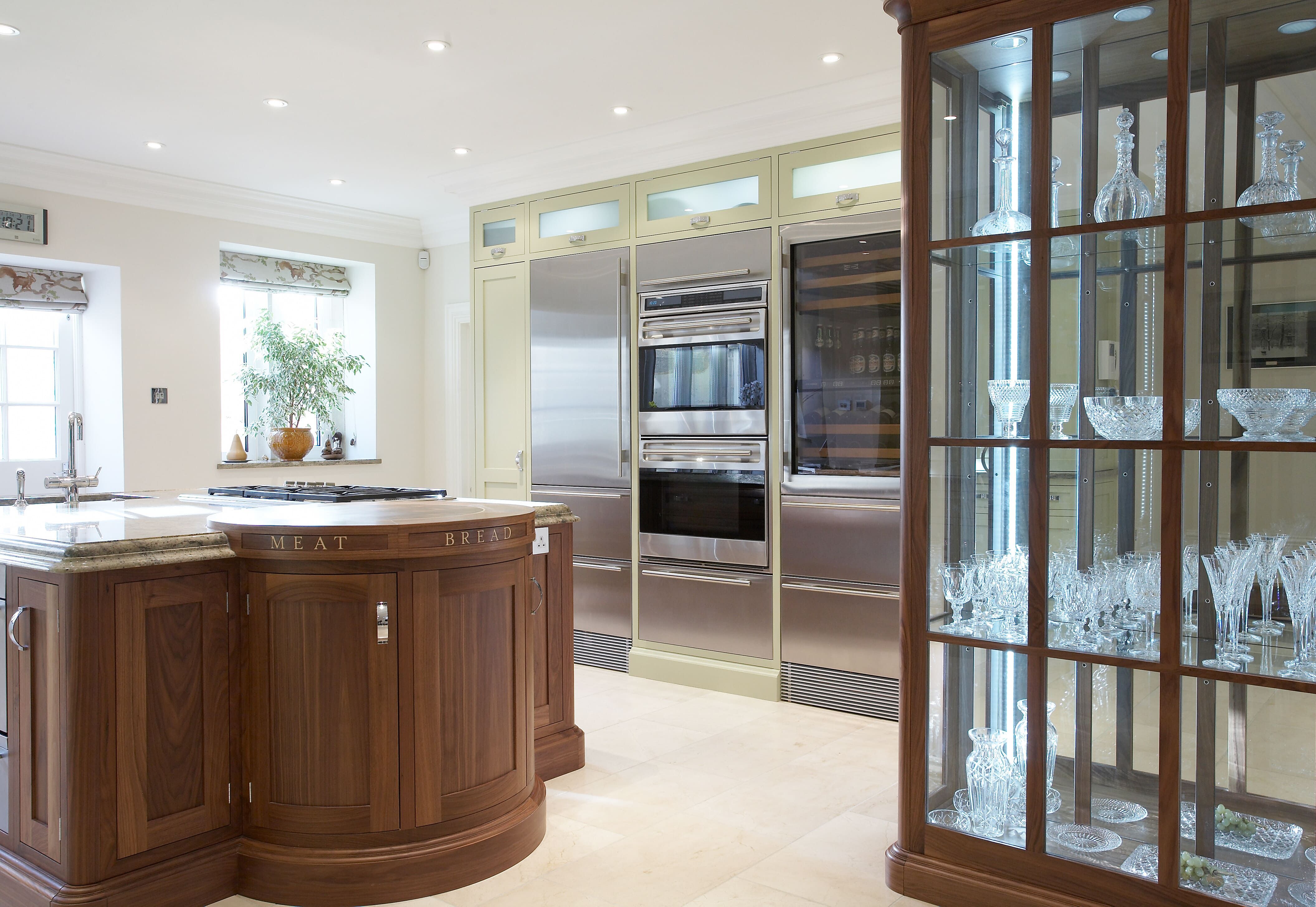 A bespoke shaker kitchen with a centre island with a wine rack, and bespoke glass shelf.