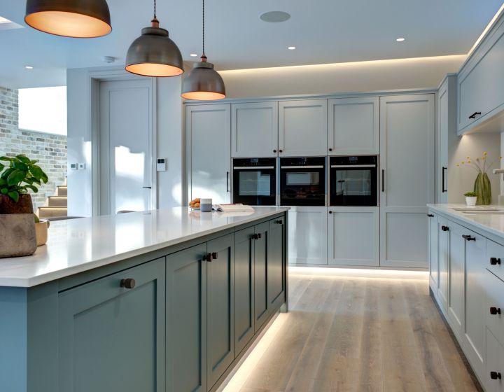 A large, bespoke shaker kitchen with a kitchen island, featuring under-counter lighting.
